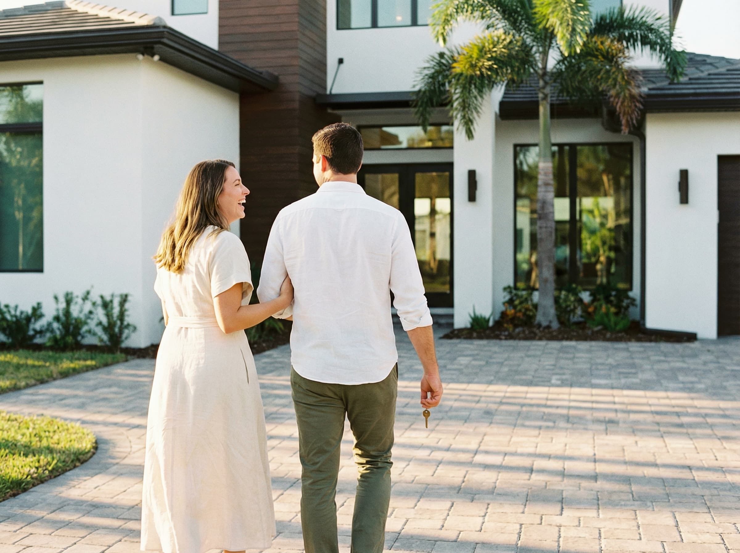 A young couple walking up to their newly purchased Florida home, holding the key